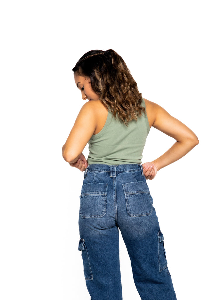 A fashionable women wearing green crop top and denim jeans